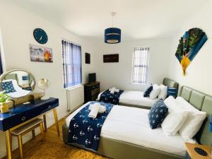 a bedroom with two beds and a mirror at Captains Rest - 2 bedroom apartment in the heart of Brixham in Brixham