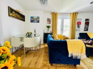 a living room with a blue couch and a table at Captains Rest - 2 bedroom apartment in the heart of Brixham in Brixham