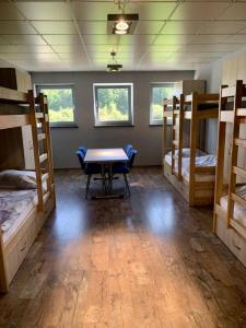 a room with a table and four bunk beds at Noclegi JuraPark Krasiejów in Krasiejów