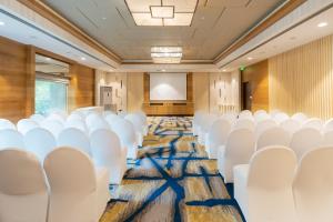 an empty conference room with white chairs and a screen at Holiday Inn Agra MG Road an IHG Hotel in Agra