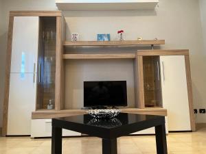 un soggiorno con TV e tavolo nero di [Apulian Heart] Elegante Appartamento a Gioia del Colle