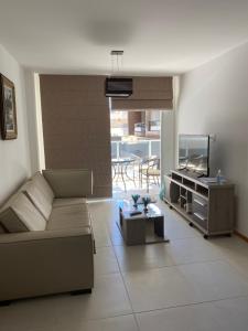 a living room with a couch and a flat screen tv at Apartament Piratininga in Niterói