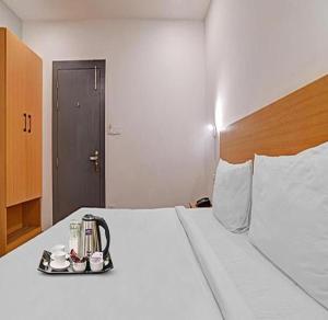Habitación de hotel con cama y bandeja de comida en FabHotel Destiny 78, en Indore