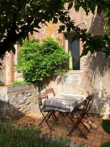 a table and chairs sitting in front of a building at Maison chaleureuse en pierres apparentes in Le Pont Legé