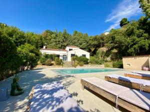 una piscina con due lettini e una casa di L'EFFERVESCENT a Saint-Péray