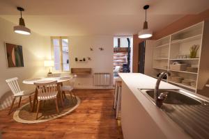 a kitchen with a sink and a table with chairs at La Cabane en Ville in Riom