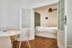 1 dormitorio con 1 cama, mesa y sillas en Appartement La Cabane, en De Panne