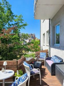 eine Terrasse mit Stühlen und Tischen auf dem Balkon in der Unterkunft Hotel in Herrenhausen in Hannover