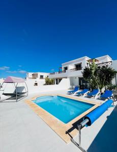 una villa con piscina di fronte a una casa di Villa Jasmine a Playa Blanca