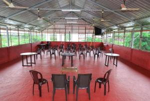 a large room with tables and chairs and a television at Castle home stays in Udupi