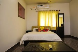 1 dormitorio con cama y mesa de cristal en Castle home stays, en Udupi