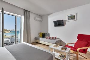 una camera d'albergo con letto, divano e finestra di Blu Acqua Hotel ad Ágios Nikólaos