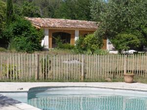 uma casa com uma piscina em frente a uma cerca em chic et champêtre em Solliès-Pont