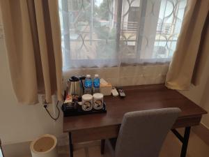 a wooden table with bottles of water and a window at HARMAN SUITES Moalboal in Moalboal