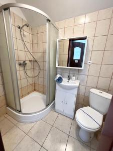 y baño con ducha, aseo y lavamanos. en Złote Piaski, en Darłowo