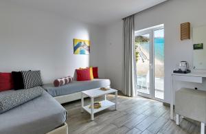 un soggiorno con divano e vista sull'oceano di Blu Acqua Hotel ad Ágios Nikólaos