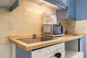 a kitchen with a microwave and a stove top oven at Smart 2BR Apt. Perfect for Longstays near Rennweg in Vienna