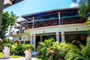 een huis met zuilen en planten ervoor bij African House Resort in Malindi