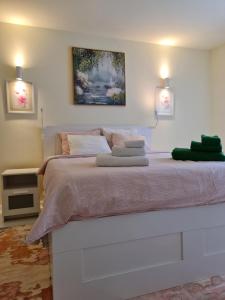 a bedroom with a large white bed with two lights at Apartamentul ALB in Buşteni