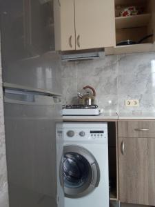 a kitchen with a washing machine and a tea kettle at Gldani-house in Tbilisi City