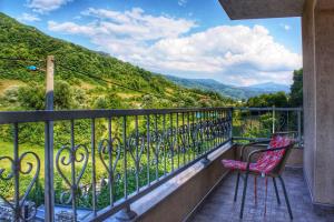 a balcony with two chairs and a view of mountains at Apartments Crvena Jabuka in Ključ