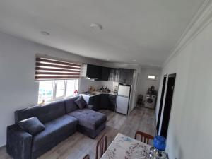 a living room with a blue couch and a kitchen at Xanbulan_Home in Aşağı Apu