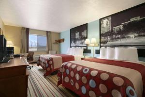a hotel room with two beds and a television at Super 8 by Wyndham Park City/North Wichita Area in Park City