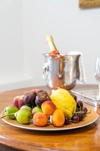 a plate of fruit on a table with a bottle of wine at Mocenigo Grand Canal Luxury Suites in Venice