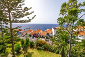 a row of houses on a street next to the ocean at Vista Oceano III in Caniço