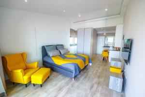 a bedroom with a bed and a yellow chair at Vista Oceano III in Caniço