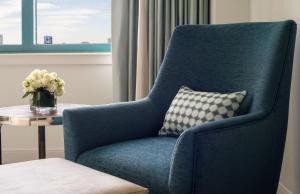 a blue chair with a vase of flowers on a table at Hyatt Regency Jacksonville Riverfront in Jacksonville