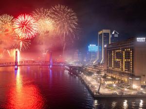 a fireworks display over a river with a city at Hyatt Regency Jacksonville Riverfront in Jacksonville