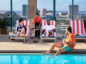 a group of people sitting around a swimming pool at Hyatt Regency Jacksonville Riverfront in Jacksonville