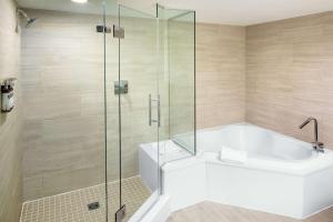 a bathroom with a tub and a glass shower at Hyatt Regency Jacksonville Riverfront in Jacksonville