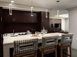 a kitchen with a kitchen island with bar chairs at Hyatt Regency Jacksonville Riverfront in Jacksonville