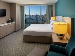 a hotel room with a large bed and a large window at Hyatt Regency Jacksonville Riverfront in Jacksonville