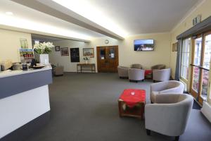 a waiting room with chairs and a red table at Townhouse Motel Cowra in Cowra