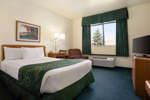 a hotel room with a large bed and a television at Travelodge by Wyndham Green River WY in Green River