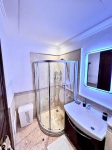 ein Bad mit einer Dusche und einem Waschbecken in der Unterkunft Sublime appartement dans résidence prestigieuse in Marrakesch