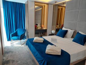 a bedroom with a bed with blue sheets and a blue chair at STEAUA DE MARE - Olimp Resort in Olimp