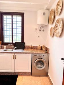 een keuken met een wasmachine en een wastafel bij Sublime appartement dans résidence prestigieuse in Marrakesh