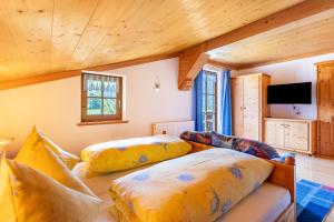 two beds in a room with wooden ceilings at Ferienwohnung Weissbacher in Sankt Martin bei Lofer