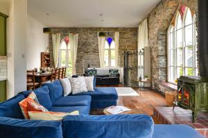 a living room with a blue couch and a fireplace at Finest Retreats - Luxury Converted Chapel with Hot Tub & Games Room in Dinas Mawddwy