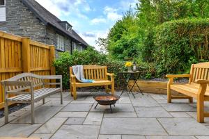 a patio with two benches and a fire pit at Finest Retreats - Luxury Converted Chapel with Hot Tub & Games Room in Dinas Mawddwy
