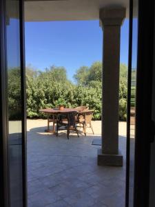 a patio with a table and a bench at Agriturismo Lu Stabbiacciu in Aglientu