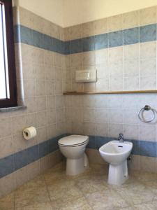a bathroom with a toilet and a sink at Agriturismo Lu Stabbiacciu in Aglientu +21 photos