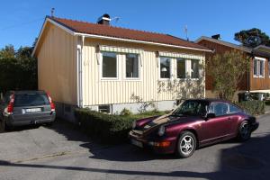 ストックホルムにあるTallkrogen Romantic House - Upper or Lower Apartmentの家の前に駐車した紫色の車