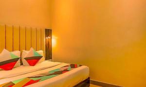 FabExpress Gateway Inn في مومباي: غرفة نوم مع سرير مع وسائد ملونة