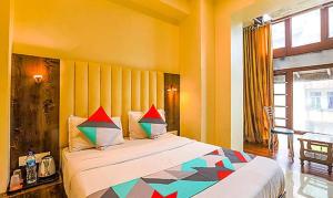 a bedroom with a large bed with colorful pillows at FabExpress Gateway Inn in Mumbai