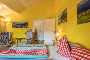 a living room with a bed and a yellow wall at Zwischen Chiemsee und Bergen Dg in Bernau am Chiemsee